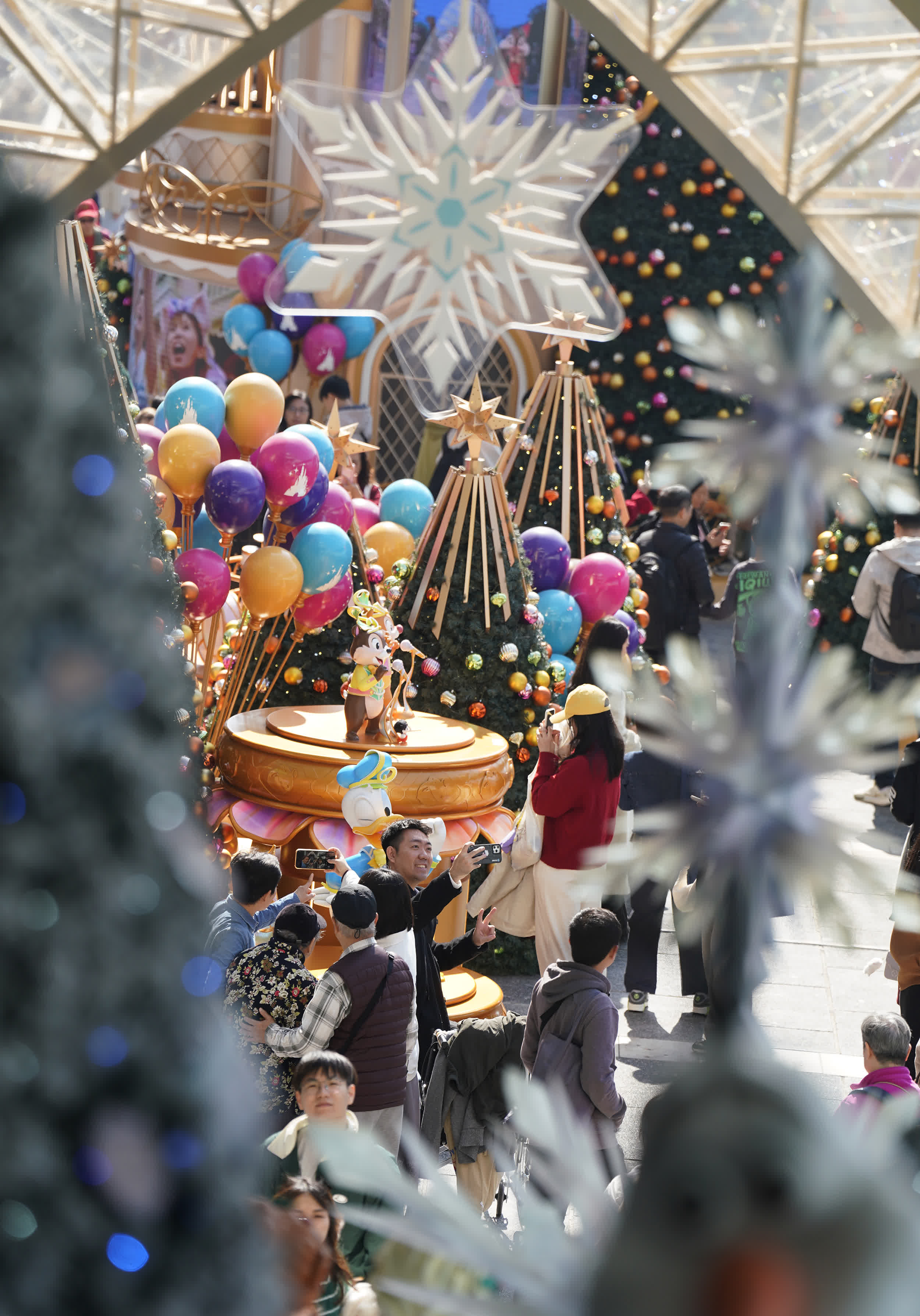 圖為遊客與市(shi)民(mín)在(zai)海港城(cheng)聖誕裝飾前(qian)拍照打卡。（香港中(zhong)通(tong)社(she))）